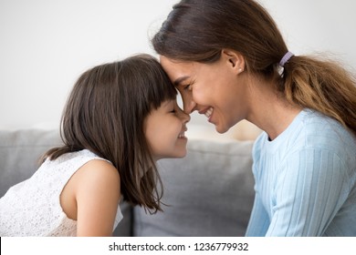 Close Up Profile Faces Smiling Mother And Daughter Touching With Foreheads With Closing Eyes. Mom Expressing Understanding Candid Emotions And Love To Sweet Little Child. Happy Friendly Family Concept