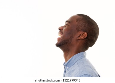 Close Up Profile Portrait Of Handsome Young Black Man Laughing Against Isolated White Background