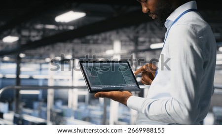 Close up of programmer swiping on tablet display in data center, doing maintenance tasks, ensuring optimal performance. IT expert checks code on device, applying patches to improve stability