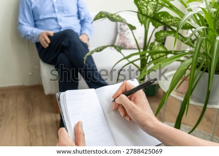Close Up of Psychologist Hand Taking Notes During Therapy Session with Client