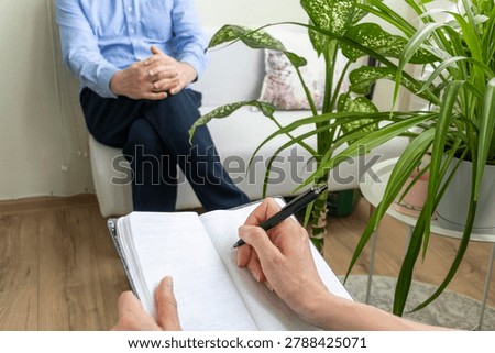 Close Up of Psychologist Hand Taking Notes During Therapy Session with Client