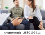 Close up of a psychologist hands during a therapy session with a young family couple. The consultation focuses on providing support, assistance, and talking through relationship challenges.