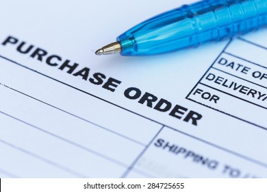 Close up purchase order with blue pen in the office, focus on paper