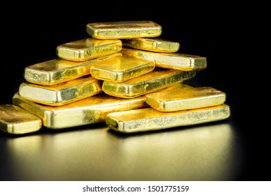 close up pure gold bar ingot put on the black color with bokeh surface background represent the business and finance concept idea, Real gold bars background