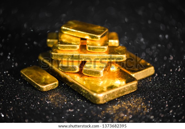 close up pure gold bar ingot put on\
the black color with bokeh surface background represent the\
business and finance concept idea, Real gold bars\
background