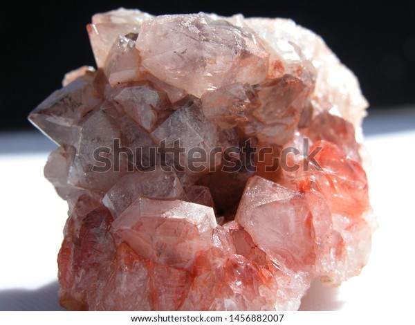 Close up of quartz\
crystals in a vug, or cave with over head lighting\
Abstract\
composition of reddish quartz crystals growing in a cave, or the\
geological term vug.