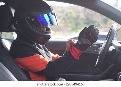 Close Up Of Race Car Driver In Car Wearing Helmet And Putting On His Gloves While Car Is Parked Unidentifiable Man