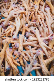 Close Up Of Raw Chicken Feet On Market Counter. Top View