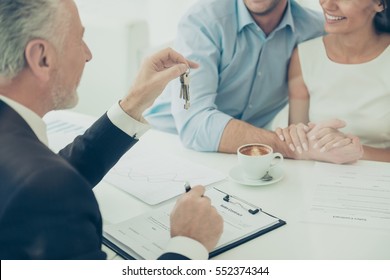 Close Up Of Real Estate Agent Giving Keys To Couple Of Customers