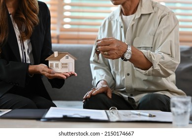 Close Up With Realtor Giving Key To Senior Aged Man, New House, Happy Older Owners Make Purchase Deal Concept.