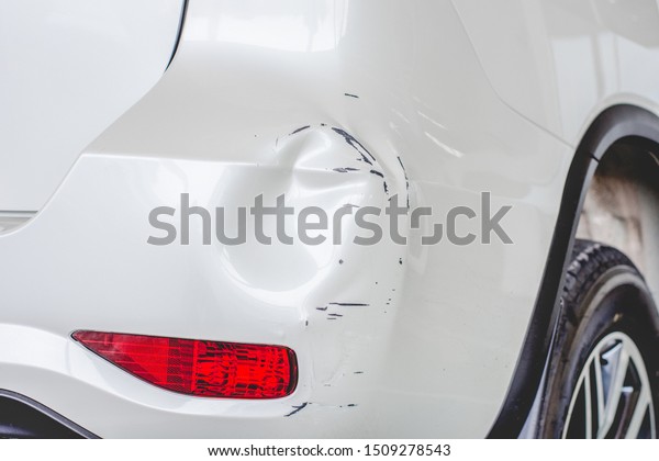 Close up  rear bumper of the car is dented from\
a car accident.