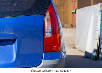 Close Up Rear Of New Blue Car Parking On The Asphalt Or Gravel Road. Brake Light Background.