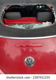 Close Up Of Rear Of Smashed Heated Glass Window On Mohair Black Soft Roof Top Of Red Convertible Beetle Cabriolet Hole To Auto Interior Back Seats With Accident Shattered Pieces And Showing VW Sign