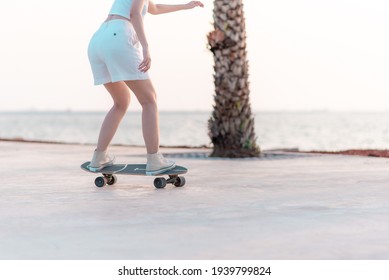 Close Up Rear View Asian Women Leg On Surf Skate Or Skate Board In Breach Background