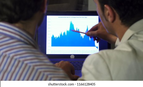 Close up rearview shot of two businessmen working together having a meeting discussing diagram on the laptop technology busy brainstrorming teamwork discussion advise experience. - Powered by Shutterstock