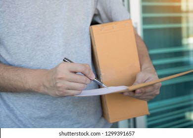 Close up recipient of the product is using the pen signing to receipt document at front of the house. - Shutterstock ID 1299391657