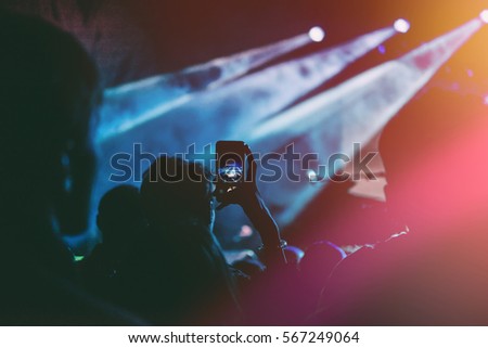 Close up of recording video with smartphone during a concert. Toned picture
