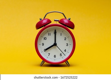 Close up red alarm clock on yellow background