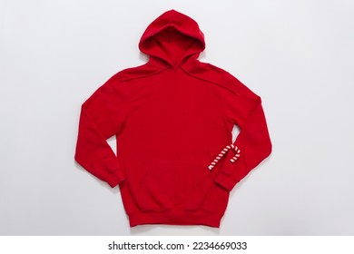 Close up red blank template hoodie copy space. Christmas Holiday concept. Top view mockup hoodie, scarf, hat. Red holidays decorations white background. Happy New Year accessories. Selective focus