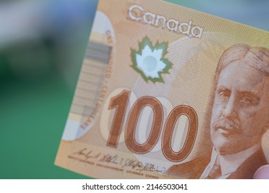 Close Up Of Red Canadian Hundred (100) Dollar Bill With Blurred Defocused Background. Macrophotography.