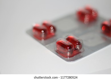 Close Up Of Red Caplet Pills Isolated On White Background. Healthcare And Drug Use Concept.