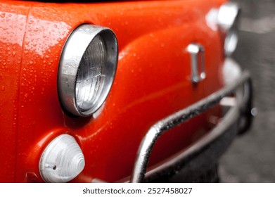 Close up of a red classic Fiat 500 parked in the streets of Rome, Italy