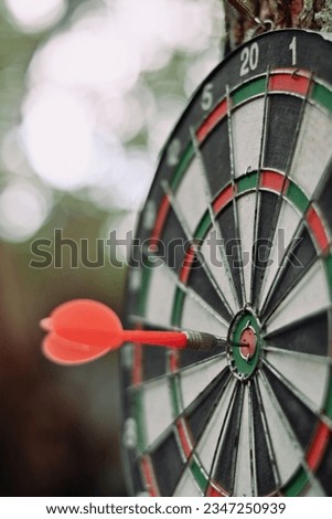 close up red dart arrow hitting on target center of dartboard, recreation and sport, planning and manage to success business wallpaper background concept