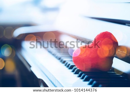 close up of the red heart on  piano keys with Bokeh light