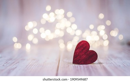 Close Up Of Red Heart On Wooden Table Against Defocused Bokeh Light Background. Love, Valentine's Day Concept.