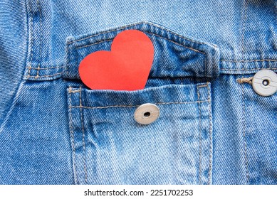 Close up of a red heart showing from a denim jacket pocket. A concept of love, friendship, St. Valentine celebration. - Powered by Shutterstock