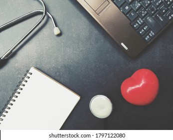 close up red heart, stethoscope, notebook and computer on table, world health day, medical and healthcare business, life insurance technology, telemedicine and global pandemic crisis risk and problem