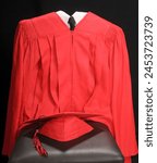 close up of a red high school or college graduation cap and gown 