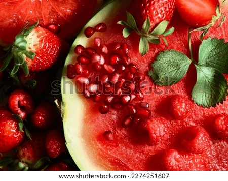 Close up of red juicy fruits: watermelon, strawberries, pomegranate . Top view