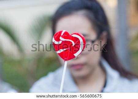 Close up red lollipop on young woman face background