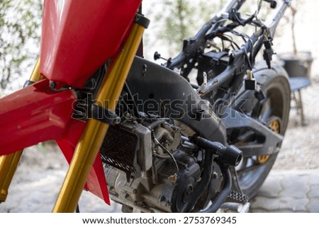 Close up of red motorcycle frame and engine during repair and assembly in workshop. maintenance process shows bike complex mechanics and custom parts being restored