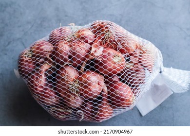 Close Up Of Red Onions In Mesh Bag