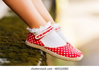 Close Up Of Red Polka Dot Shoes On Child's Feet