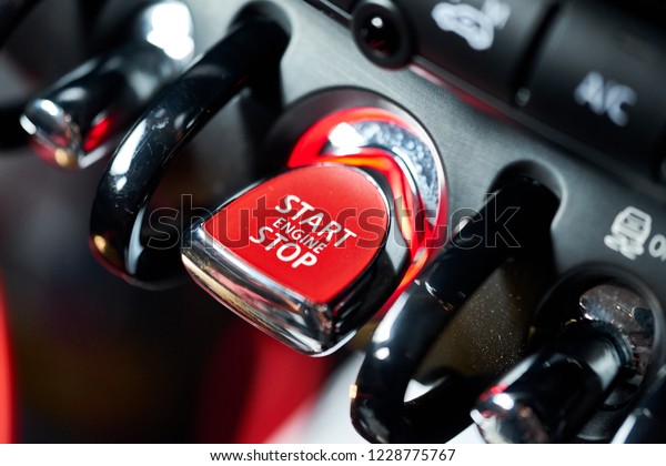 Close up of red push start button background.\
Modern luxury supercar engine start stop button switch. Keyless car\
engine ignition system. Concept of self motivation and improvement\
background.