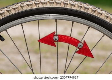 Close up of a red reflector on the bicycle wheel. Safety device. Bike wheel reflector.