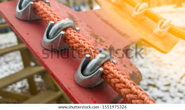 Close up of red rope and metal clips used for
suspension bridge to the rope
Park.