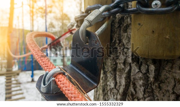 Close up of red rope and metal clips used for
suspension bridge to the rope
Park.
