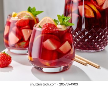 close up of red sangria glasses on white kitchen table