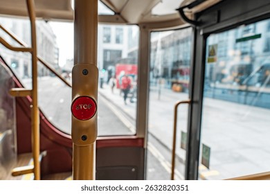 Close Up of the Red Stop Button on a London Bus with the City Street Visible Through the Window, Capturing the Everyday Commuter Experience.