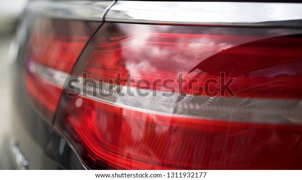Close up of red tail lights, detail of modern,\
luxury, black SUV. Stock. Black car break lights, automotive\
lighting concept.