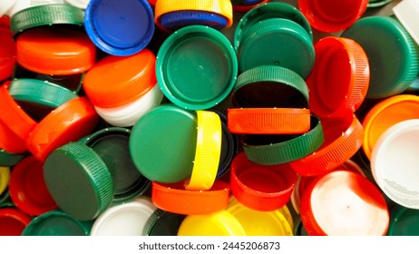 Close up of red, white, blue, yellow and green caps from plastic bottles. plastic collection. copy space. plastic recycling. round lids for milk and juice. view from above - Powered by Shutterstock