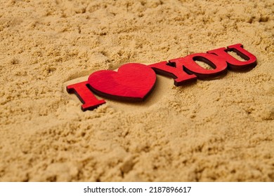 Close Up Red Wooden I Love You Cutout On The Sand. Honeymoon Vacation Concept.