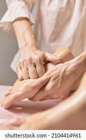 Close Up Reflexology Foot Massage. Professional Therapist Giving Leg And Foot Massage To A Woman In Spa. Female Massage Therapist Massaging Clients Legs. Body Relaxation And Skin Care