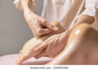 Close Up Reflexology Foot Massage. Professional Therapist Giving Leg And Foot Massage To A Woman In Spa. Female Massage Therapist Massaging Clients Legs. Body Relaxation And Skin Care