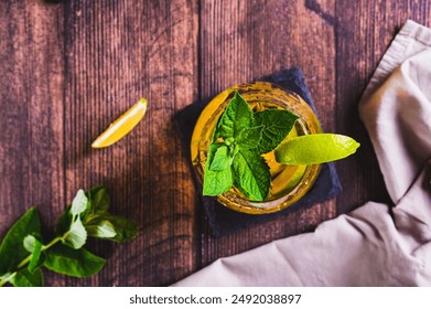 Close up of refreshing iced tea with mint and lime in a glass on the table top view