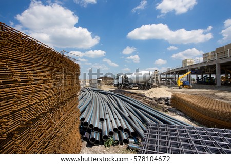 Close up of reinforcement mesh on pile and other construction material and equipment at building site